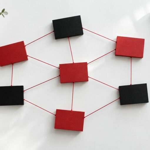 Tarjetas rojas y negras unidas por hilos rojos formando una red de afiliación sobre una mesa blanca